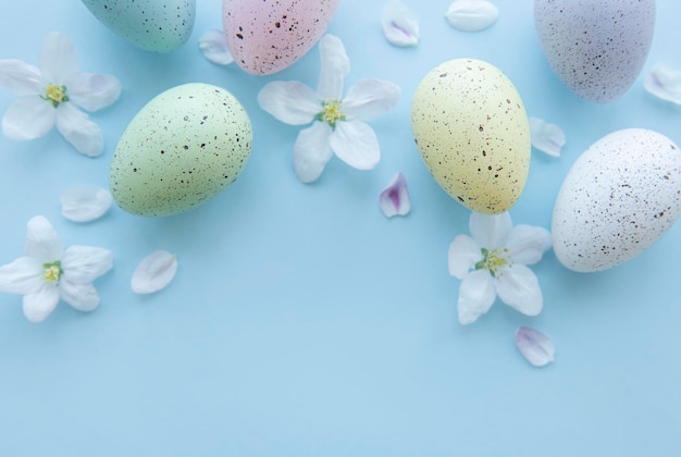 Vue de dessus des oeufs de pâques colorés sur fond bleu