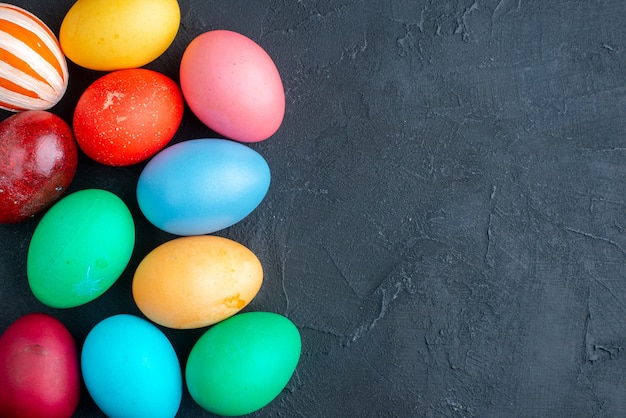 vue de dessus des oeufs de pâques colorés sur une surface sombre