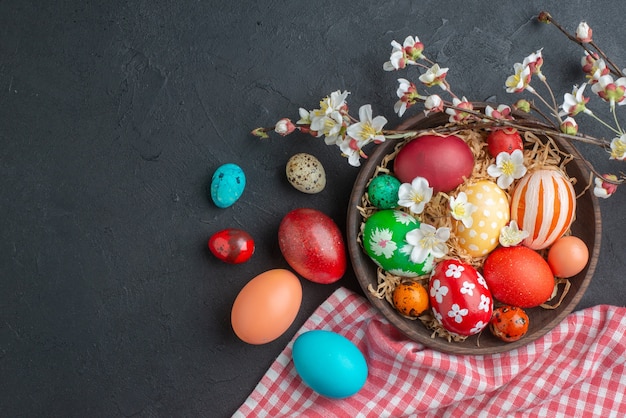 vue de dessus des oeufs de pâques colorés sur une surface sombre