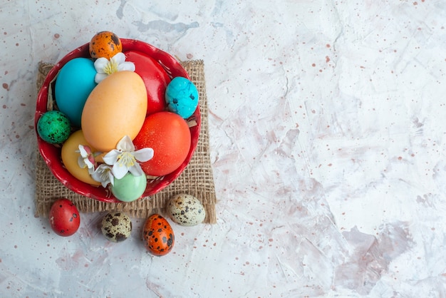 Vue de dessus des oeufs peints de couleur à l'intérieur de la plaque sur fond blanc vacances de printemps novruz horizontale ornée