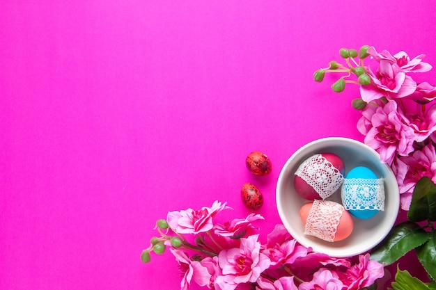Vue de dessus des œufs peints de couleur à l'intérieur de la plaque sur une surface rose concept de vacances ethniques Novruz printemps coloré orné