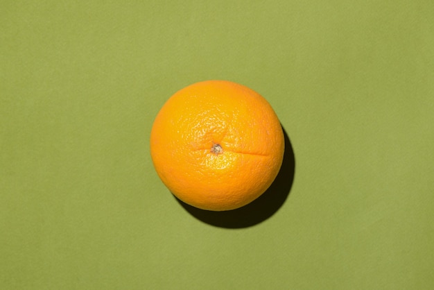 Vue de dessus d'une orange sur fond vert.