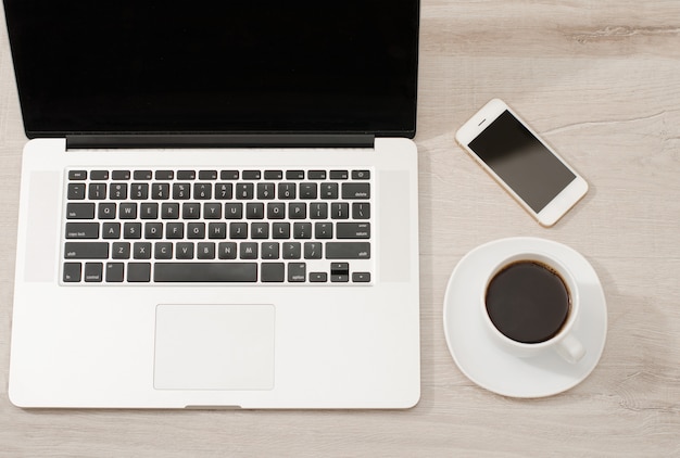 Vue de dessus d'un ordinateur portable, d'un téléphone intelligent et d'une tasse de café