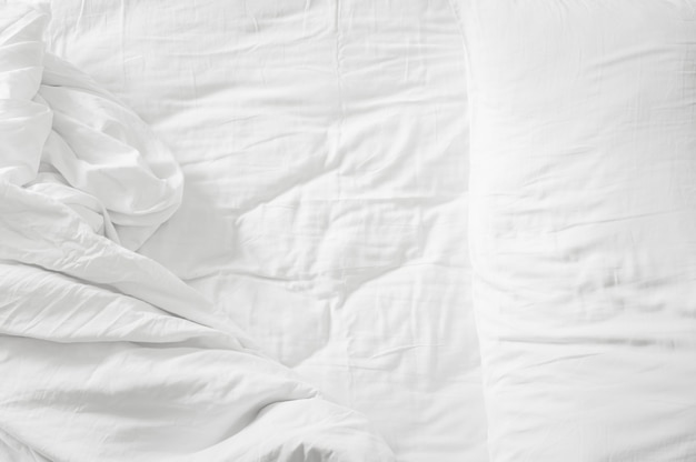 Vue de dessus oreillers blancs et couverture sur drap de lit vide