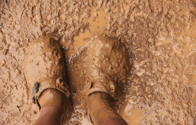 Vue de dessus de la paire de chaussures de trekking dans la boue