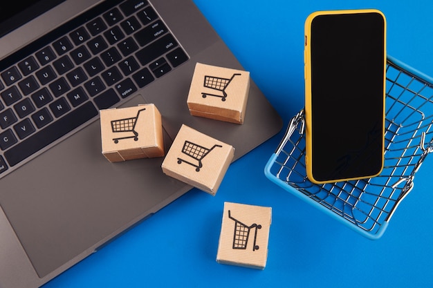 Vue de dessus sur un panier, des boîtes et un téléphone mobile sur un bleu