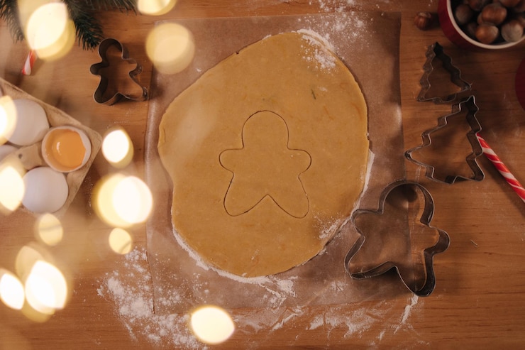 Photo vue de dessus de la pâte crue pour la cuisson des biscuits de noël hommes au gingembre sur une table en bois se préparant à la cuisson