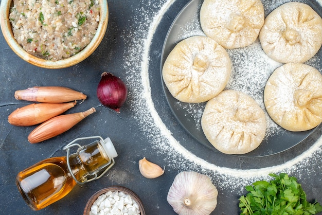 Vue de dessus de petites boulettes crues avec différents ingrédients sur fond gris nourriture tarte gâteau cuire savoureuse pâte de viande couleur cuire au four