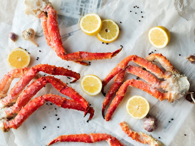 Vue De Dessus Des Phalanges De Crabe Frais Au Citron Et Aux épices Sur Papier Froissé.