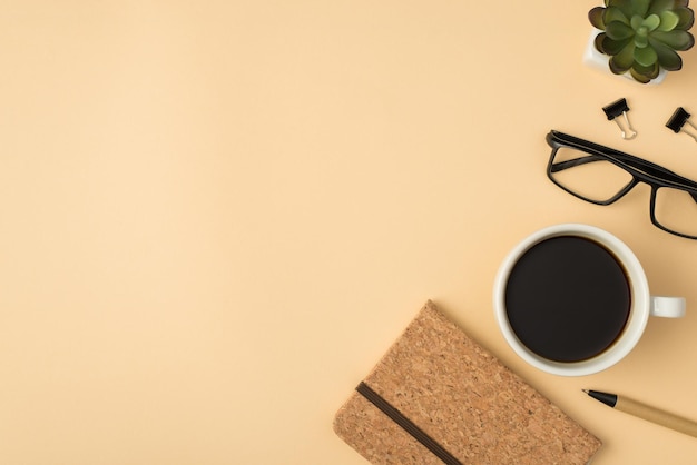 Vue de dessus photo de verres de plantes tasse de café et planificateur fermé sur fond beige isolé avec fond