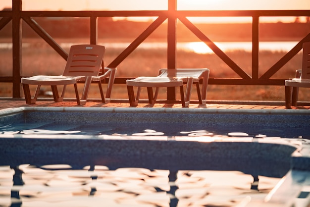 Vue de dessus de la piscine à l'eau claire en vacances sur fond de coucher de soleil