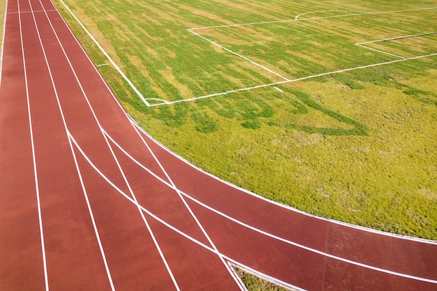 Vue de dessus des pistes de course rouges et de la pelouse d'herbe verte. Infrastructure pour les activités sportives.