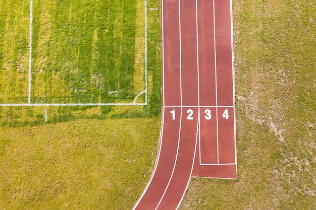 Vue de dessus des pistes de course rouges et de la pelouse d'herbe verte. Infrastructure pour les activités sportives.