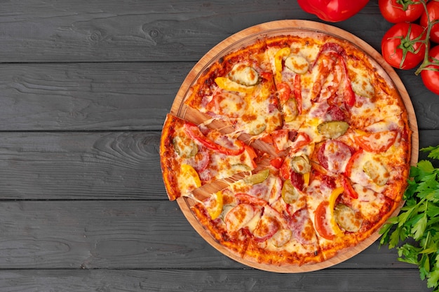 Vue de dessus de la pizza chaude sur la table en bois noire