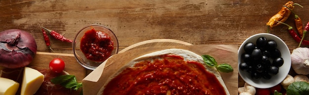 Vue de dessus de la pizza et des ingrédients sur la photo panoramique de fond en bois