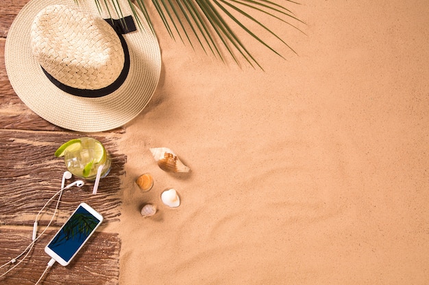 Vue de dessus de la plage de sable avec porte-serviettes et accessoires d'été. Arrière-plan avec copie espace et texture sable visible. Bordure droite en serviette