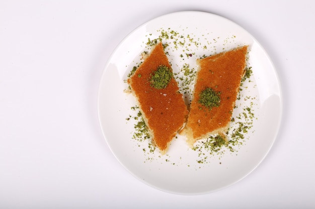 Vue de dessus de la plaque kunafa pâtisseries sucrées arabes traditionnelles isolées sur fond blanc