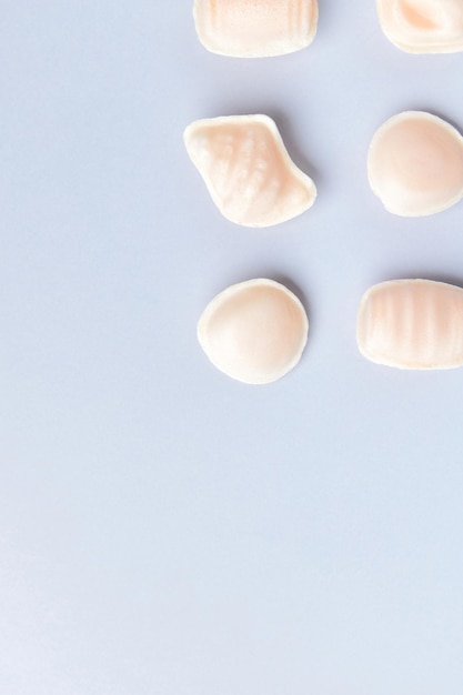 Vue de dessus à plat des bonbons traditionnels portugais au jaune d'oeuf Ovos Moles de Aveiro sur fond bleu Gastronomie tourisme