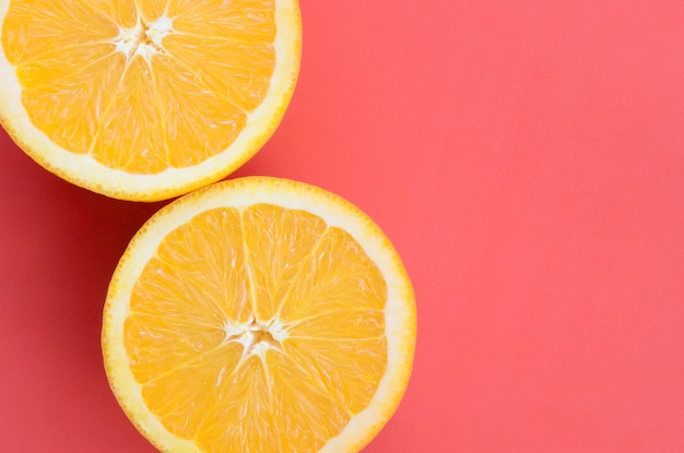 Vue de dessus de plusieurs tranches de fruits orange sur fond clair de couleur rouge