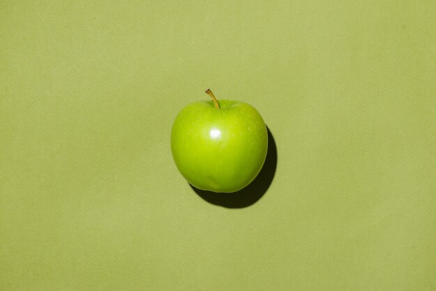 Vue de dessus d'une pomme sur fond vert.