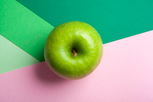 Vue de dessus pomme verte granny smith entière isolée sur fond vert et rose