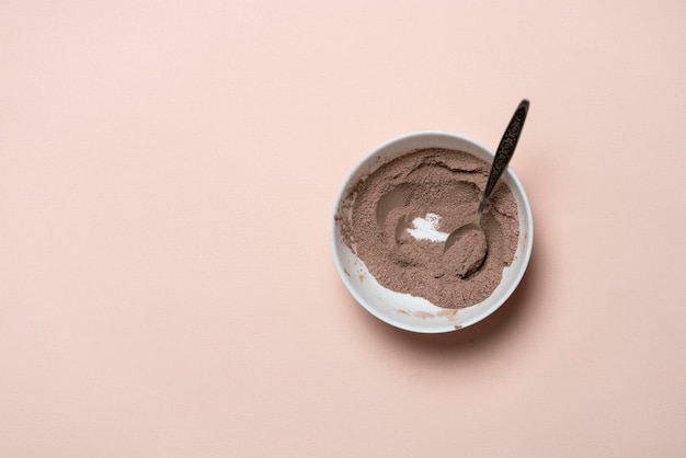 Une vue de dessus de la poudre de cacao sucré brun dans un bol blanc