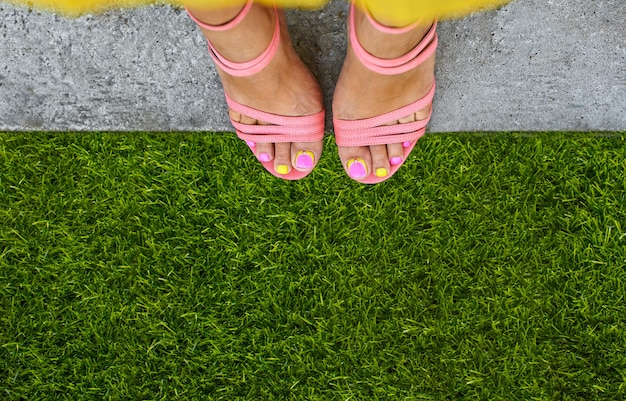 Vue de dessus, à la première personne, des pieds de femmes en sandales avec des chaussettes ouvertes. Belle pédicure