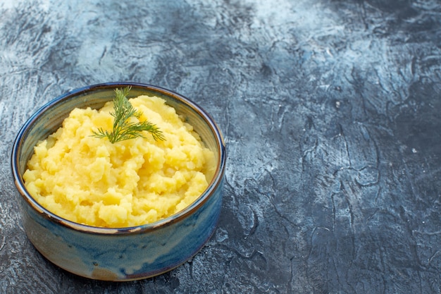 Vue de dessus de la purée de pommes de terre servie avec de l'aneth sur le côté droit sur fond de couleur sombre avec espace libre