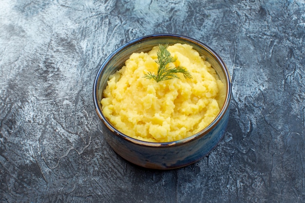 Vue de dessus de la purée de pommes de terre servie avec de l'aneth sur fond de couleur sombre avec espace libre