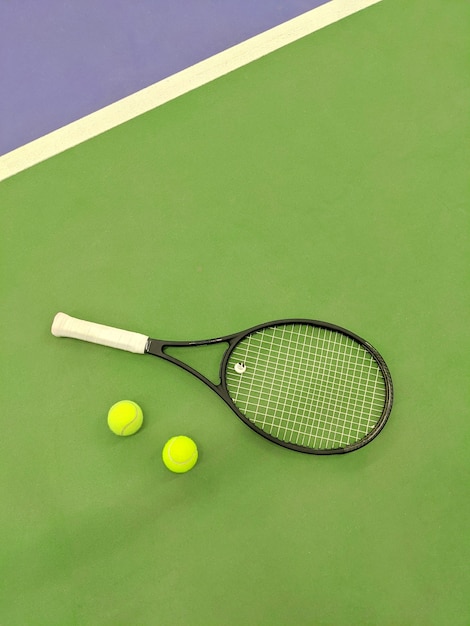 Vue De Dessus De La Raquette De Tennis Et De Deux Balles Sur Le Court De Tennis En Terre Battue Verte.