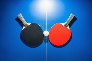 Vue De Dessus Raquette De Tennis De Table Noire Et Rouge Et Une Balle De  Ping-pong Blanche Sur La Table De Ping-pong Bleue Avec Un Projecteur  Lumineux, Deux Raquettes De Tennis De