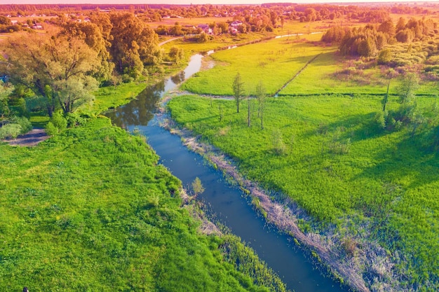 Vue de dessus de la rivière sinueuse de la campagne et des fossés d'irrigation au printemps