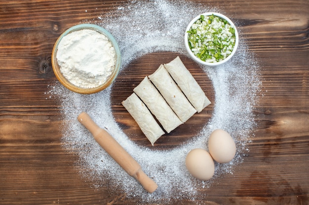 vue de dessus des rouleaux de pita avec des verts et de la farine