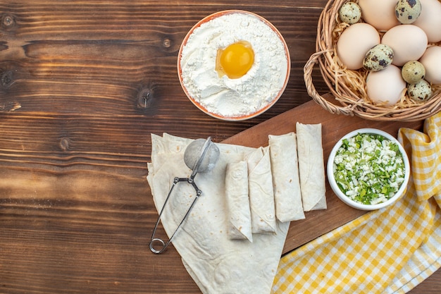 vue de dessus des rouleaux de pita verts avec des œufs et de la farine