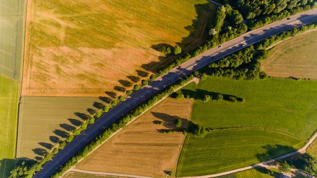 Vue de dessus de la route goudronnée passe à travers le champ.