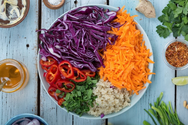 Vue de dessus de la salade de chou rouge végétarienne et du quinoa dans un bol sur fond de bois bleu