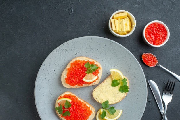 vue de dessus des sandwichs au caviar au citron et au fromage sur la surface sombre