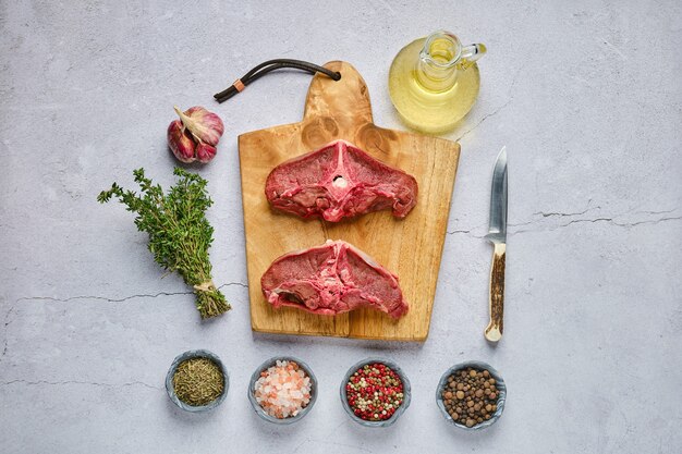 Vue de dessus de la sangle de cerf frais cru avec des épices et des herbes sur fond de béton