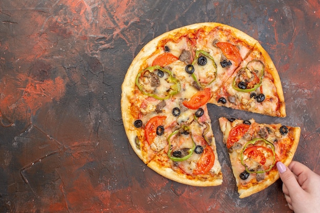 Vue de dessus savoureuse pizza au fromage tranchée et servie sur une surface brun foncé