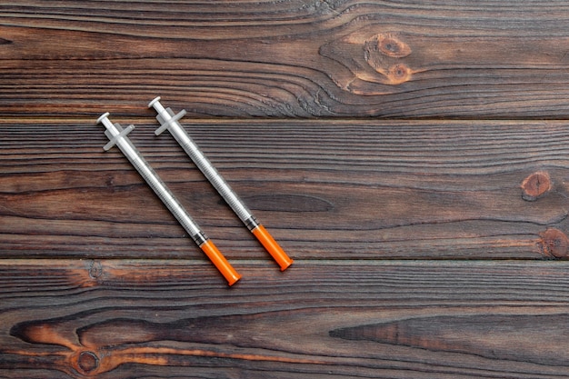Vue de dessus de la seringue à insuline préparée pour l'injection à fond en bois