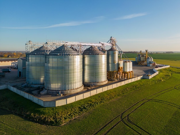 Vue de dessus des silos d'argent sur l'agro-usine pour le traitement, le séchage, le nettoyage et le stockage des produits agricoles farine céréales et céréales