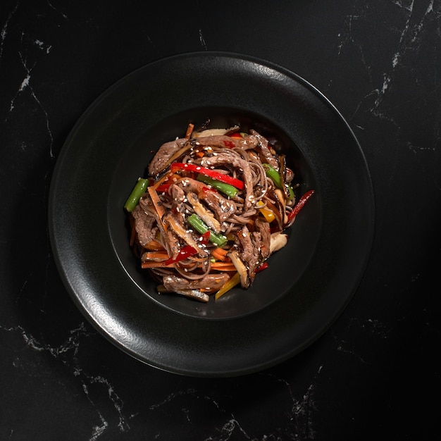 Vue de dessus Soba boeuf et légumes Nouilles de sarrasin sur fond de pierre sombre Cuisine asiatique Menu Wok