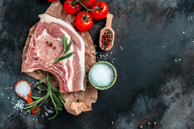 Vue de dessus steak de côtelette de porc cru sur fond sombre Bannière de nourriture biologique menu recette place pour le texte