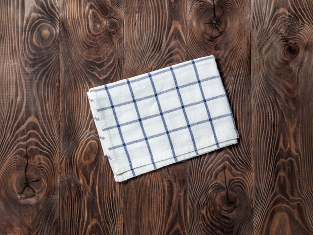 Photo vue de dessus sur une table en bois marron avec un torchon en lin ou une serviette en textile.