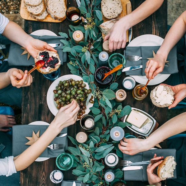 Vue de dessus sur une table à manger décorée avec des gens et de la nourriture