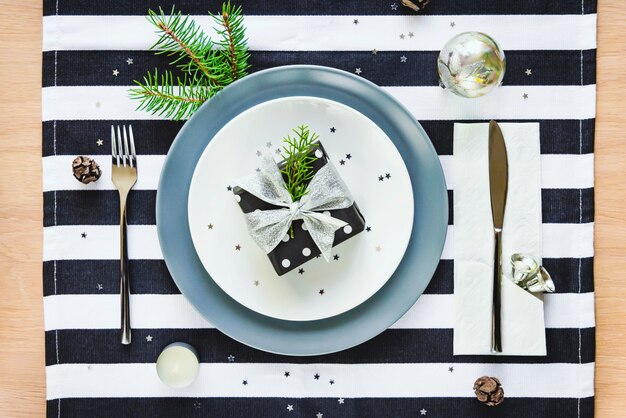 Vue de dessus de la table de Noël. Un coffret cadeau dans une assiette.