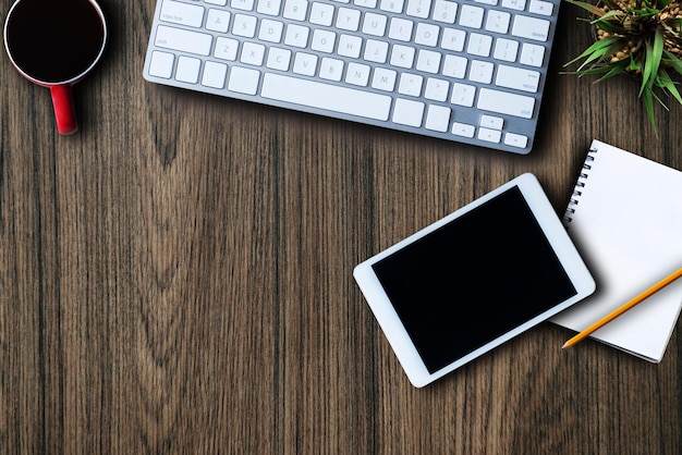 Vue de dessus Table de travail de bureau avec clavier tasse à café tablette fournitures Mise à plat