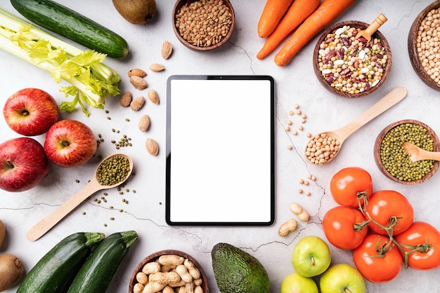 Vue de dessus d'une tablette avec écran blanc pour une maquette avec des aliments sains
