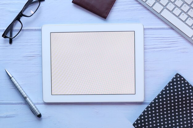 Vue de dessus de la tablette numérique avec les fournisseurs de bureau sur la table.