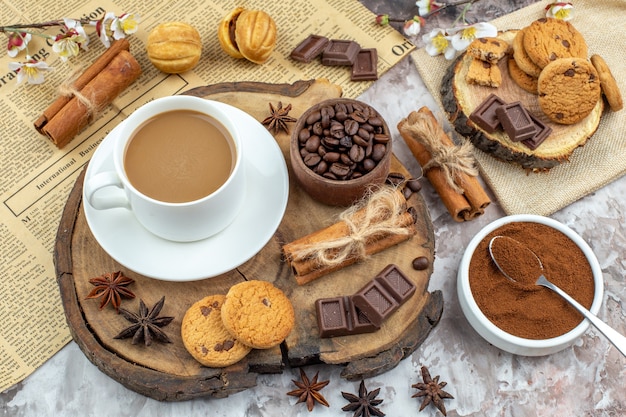 vue de dessus tasse de biscuits au café bol avec grains de café torréfiés bâtons de cannelle au chocolat anis sur planche de bois bol de cacao